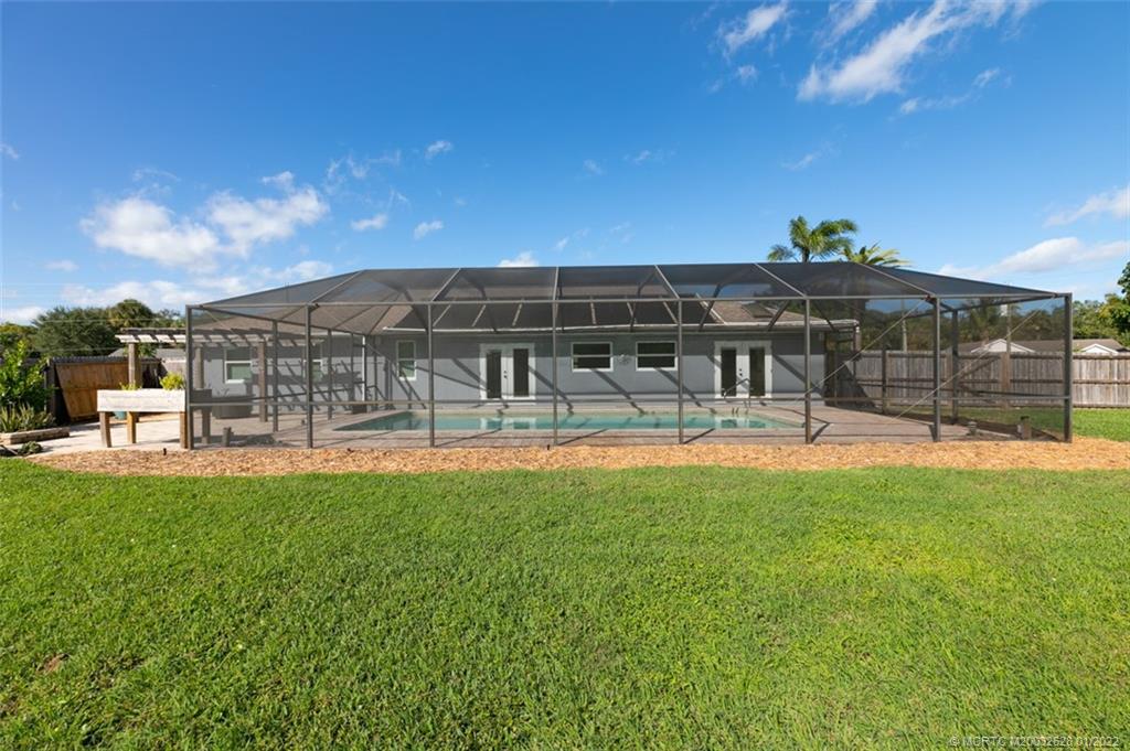2891 Southeast Farley Road Port St. Lucie, FL 34952 - Photo 36 of 53 a view of a building with a swimming pool and a yard