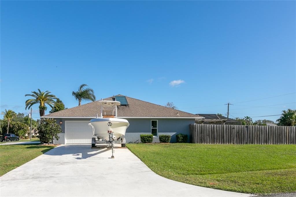 2891 Southeast Farley Road Port St. Lucie, FL 34952 - Photo 41 of 53 a patio with a table and chairs under an umbrella