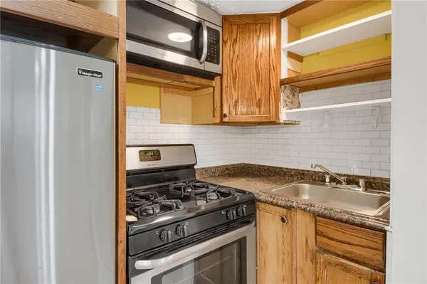 a kitchen with granite countertop a stove and a sink