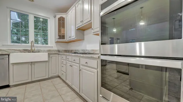 an empty room with wooden floor a fireplace and windows