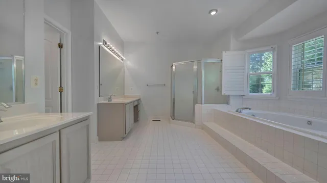 an empty room with a chandelier fan and windows