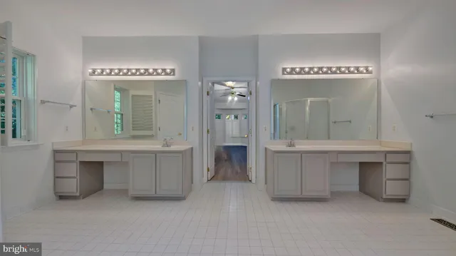 a view of an empty room and a chandelier fan