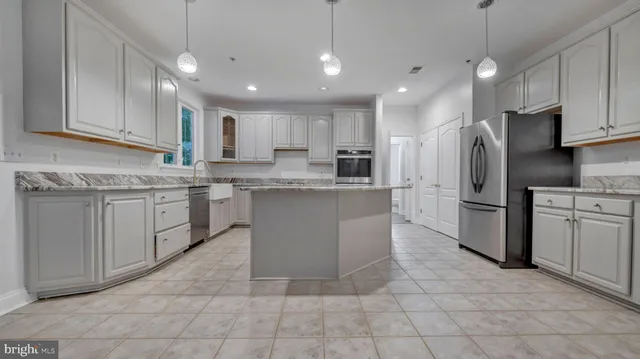 a kitchen with granite countertop white cabinets and a sink