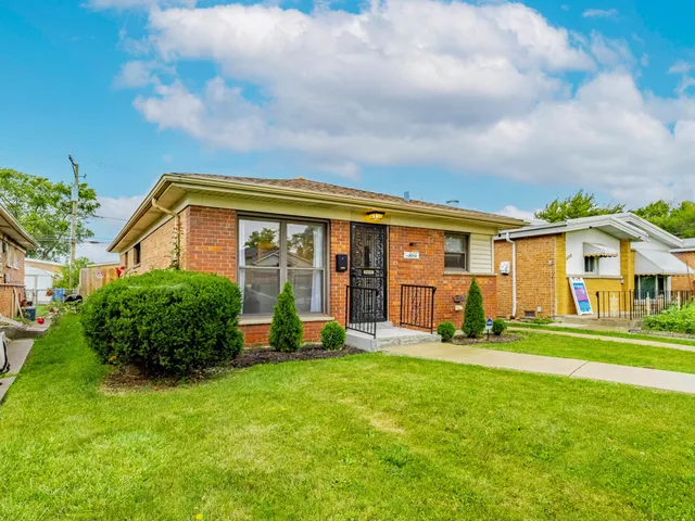 a front view of a house with a yard and trees