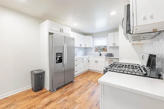 a kitchen with stainless steel appliances a refrigerator sink and cabinets