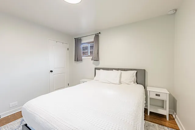 a large bed sitting in a bedroom next to a window