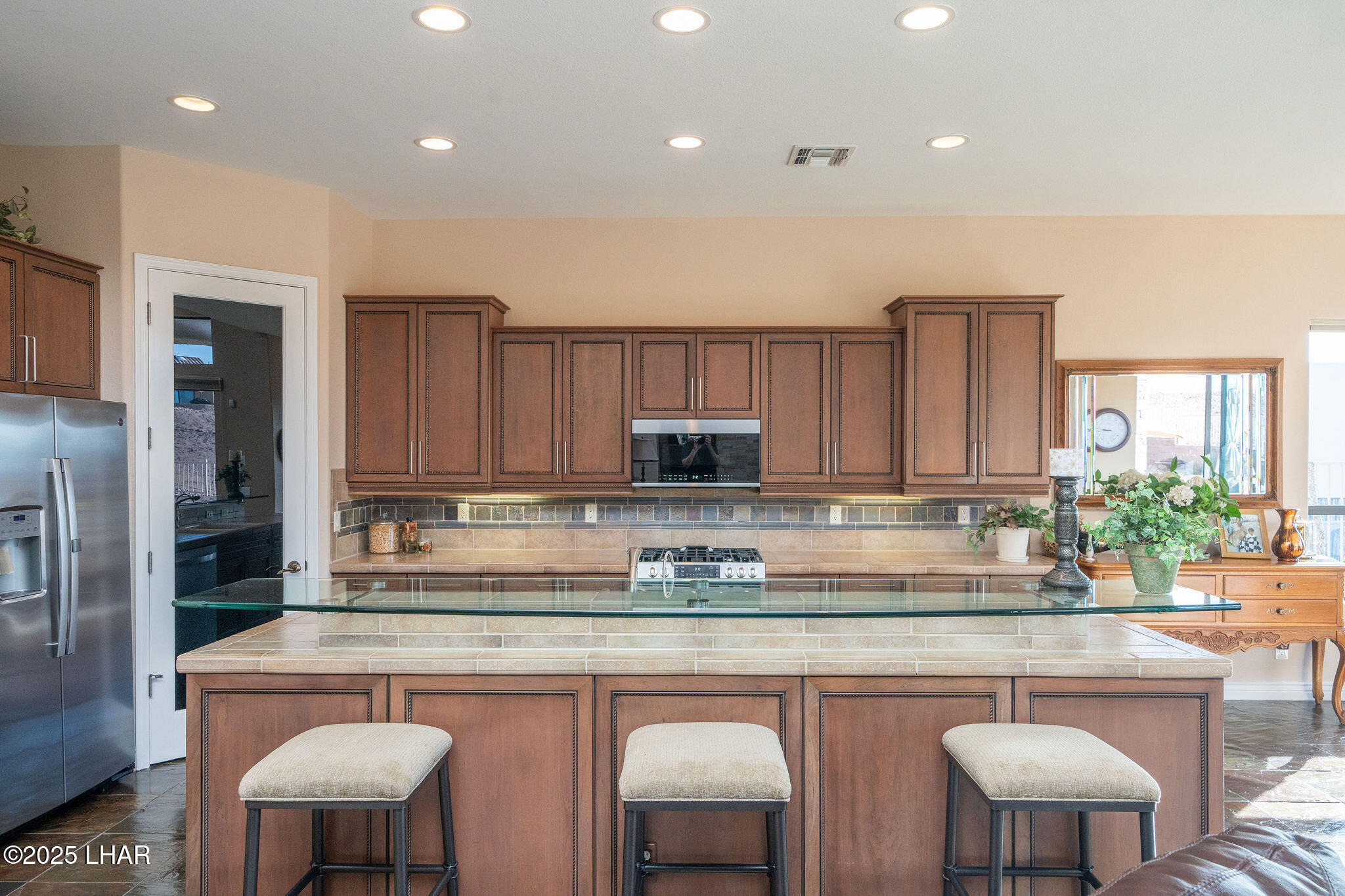 3553 North Swilican Bridge Road Lake Havasu City, AZ 86404 - Photo 12 of 104 a kitchen with stainless steel appliances granite countertop a table chairs sink and cabinets