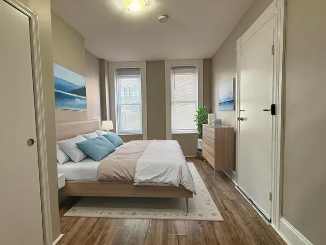 a bedroom with a bed and wooden floor