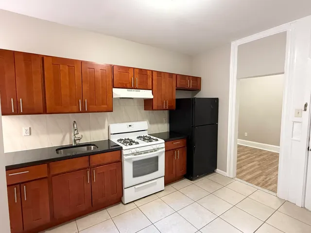 a kitchen with stainless steel appliances granite countertop a refrigerator stove and sink