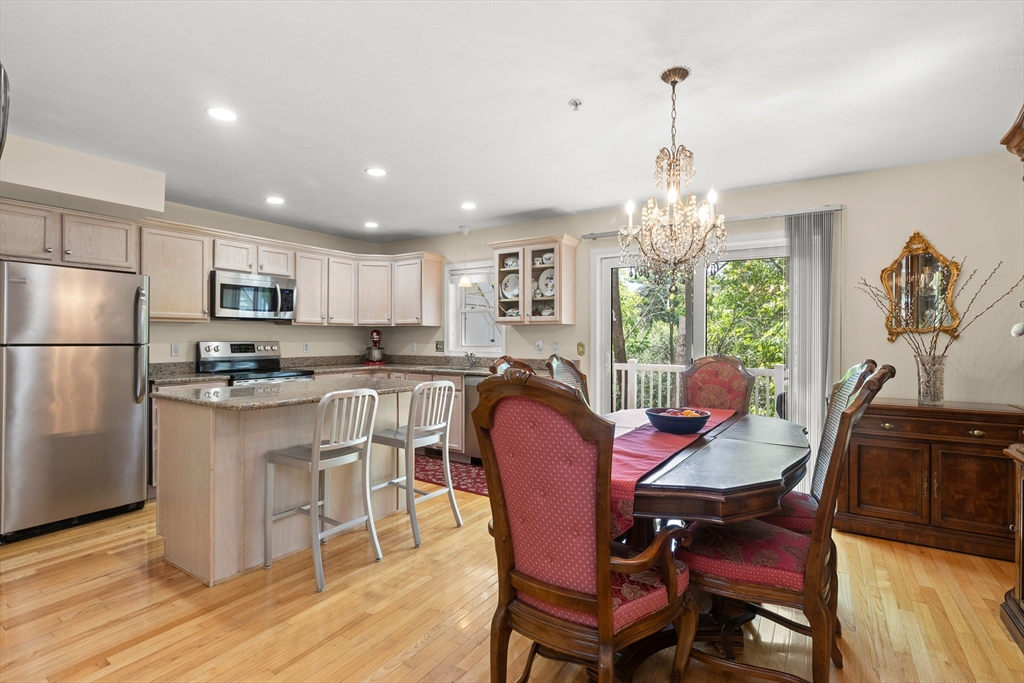 35 Collins Street, Unit 87 Danvers, MA 01923 - Photo 1 of 28 a kitchen with stainless steel appliances granite countertop a dining table chairs refrigerator and microwave