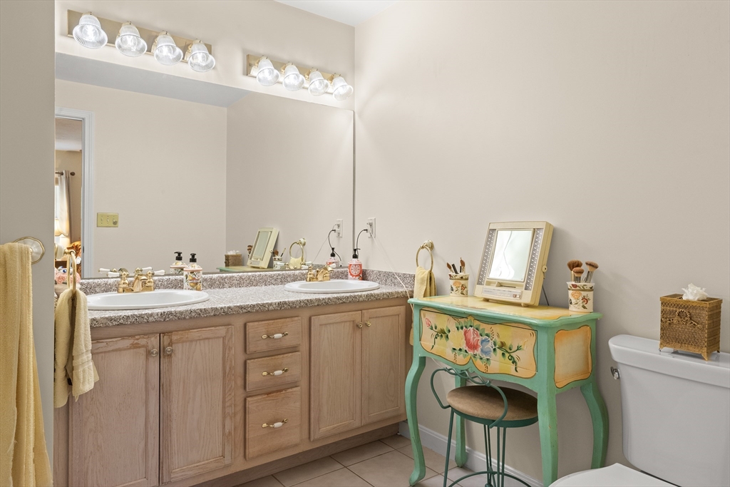 35 Collins Street, Unit 87 Danvers, MA 01923 - Photo 14 of 28 a bathroom with a sink a toilet and mirror