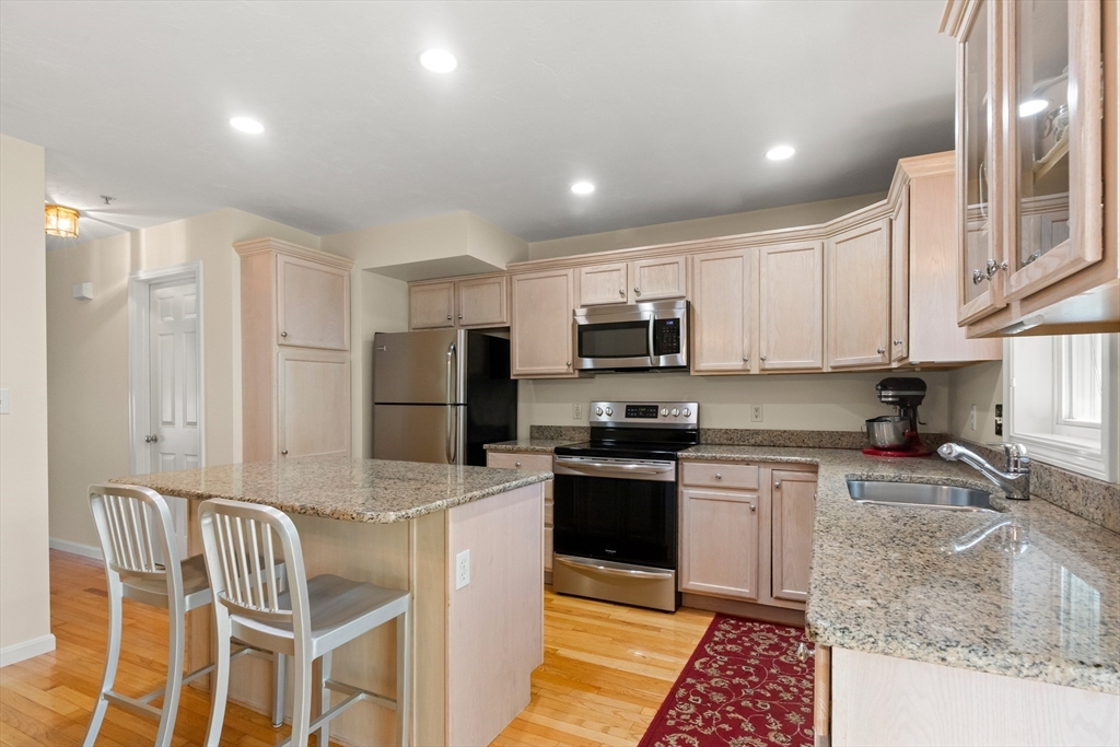 35 Collins Street, Unit 87 Danvers, MA 01923 - Photo 4 of 28 a kitchen with wooden cabinets and stainless steel appliances