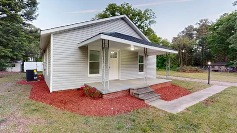 a view of a house with backyard and tree