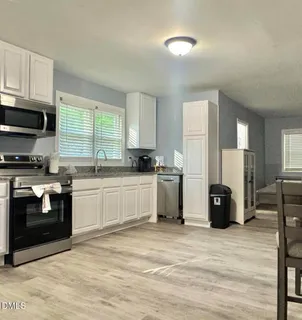 a kitchen with granite countertop a refrigerator and a stove top oven