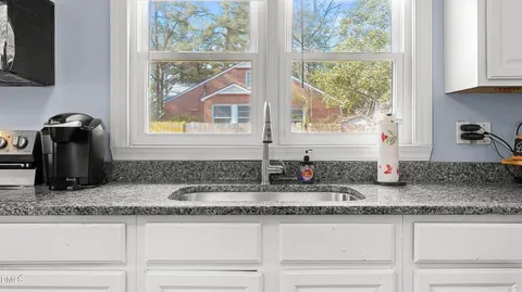 a kitchen with granite countertop a sink and a window