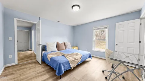 a bedroom with a bed and wooden floor