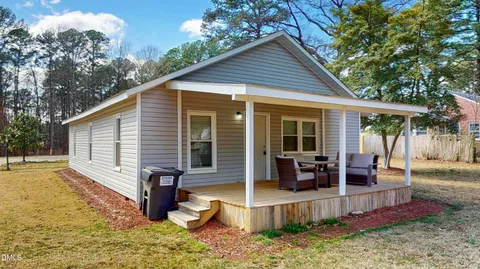 a view of a house with backyard and sitting area