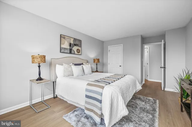 a spacious bedroom with a bed and a potted plant on table