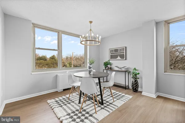 a dining room with chandelier and wooden floor