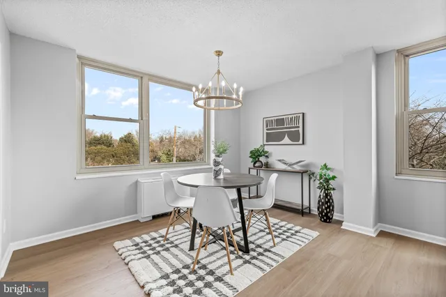a dining room with chandelier and wooden floor