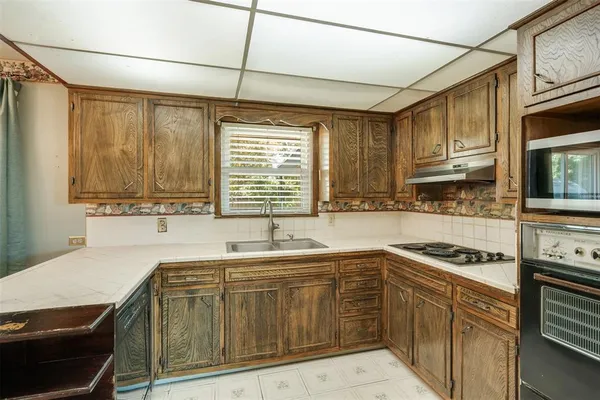a kitchen with stainless steel appliances granite countertop a sink and a stove
