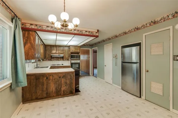 a large kitchen with a stove a refrigerator and a fireplace