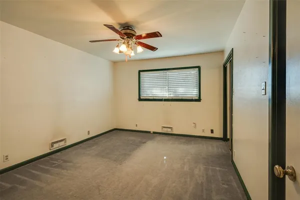 an empty room with a window and a fan