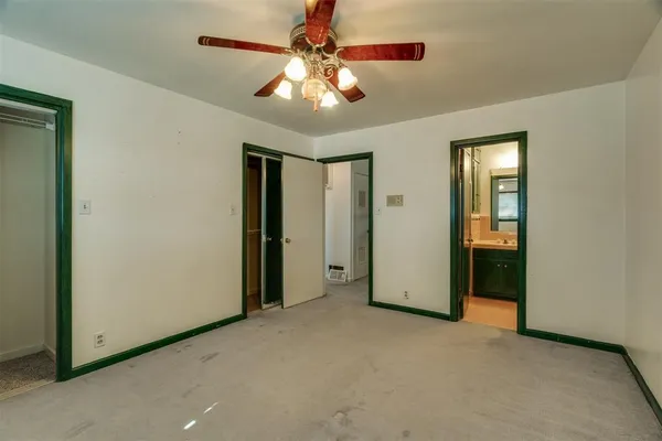an empty room with closet and a chandelier fan