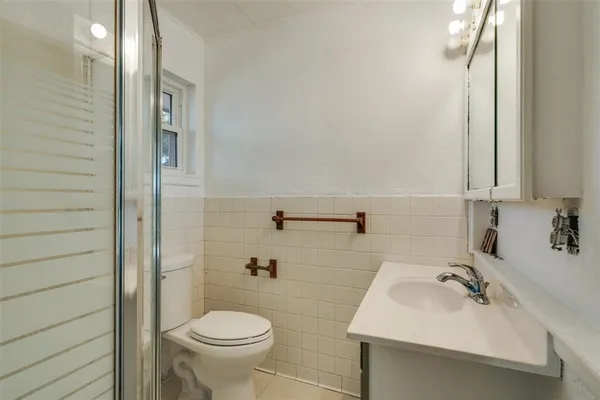 a bathroom with a sink toilet and a mirror