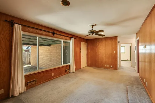 an empty room with mirror and windows