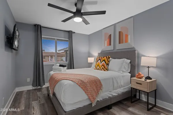 a bedroom with a bed and a lamp on the dresser