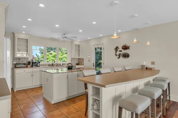 a kitchen with stainless steel appliances granite countertop a table and chairs