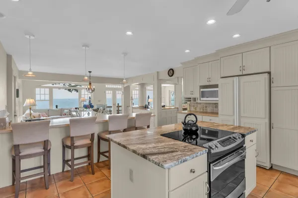 a kitchen with granite countertop a stove and white cabinets