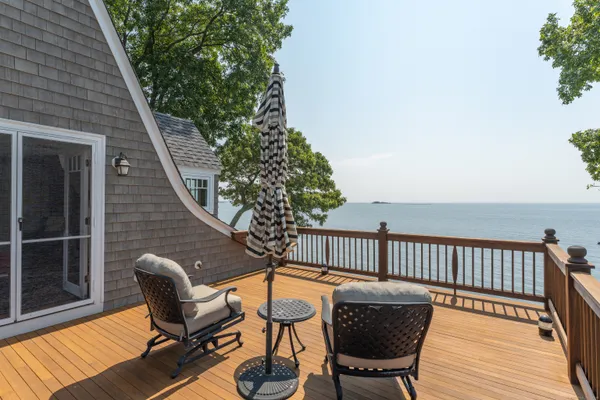a balcony with wooden floor table and chairs