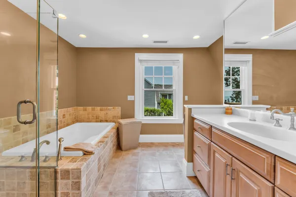 a bathroom with a tub sink and mirror