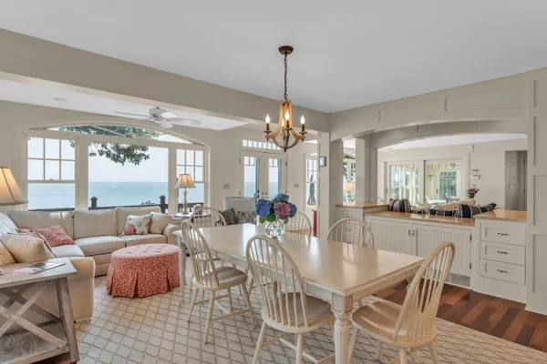 a dining room with furniture a chandelier and wooden floor