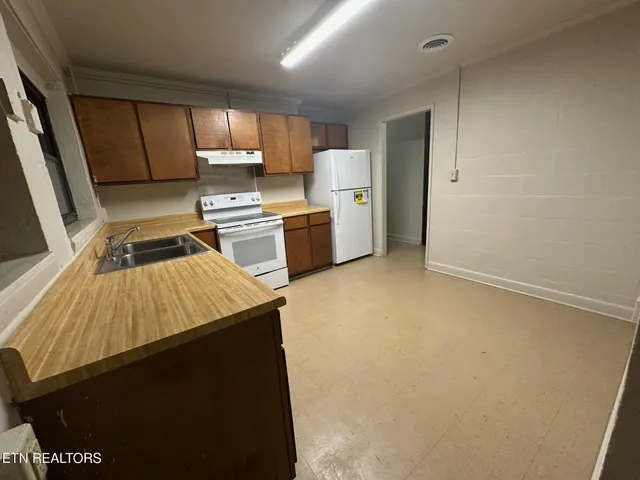 a kitchen with a refrigerator and a stove top oven