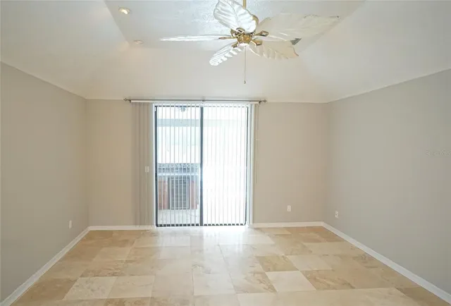 an empty room with windows and ceiling fan