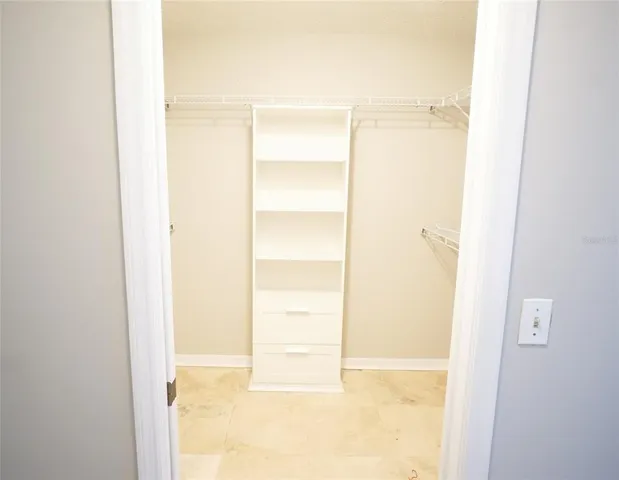an empty room with a ceiling fan and window