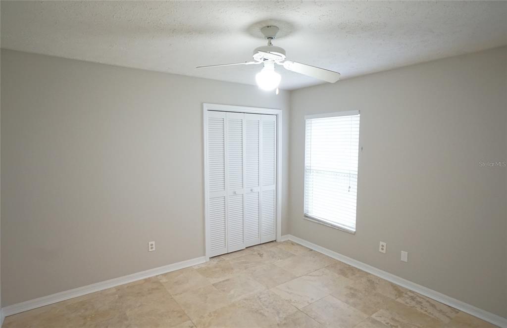 3807 Turkey Oak Drive Valrico, FL 33596 - Photo 27 of 44 an empty room with windows and chandelier fan