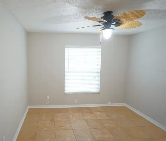 an empty room with a window and a fan