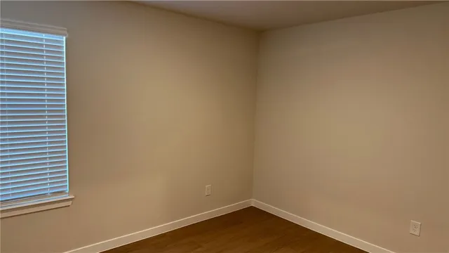 a view of a small space with wooden floor and a window