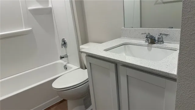 a white toilet sitting next to a bath tub
