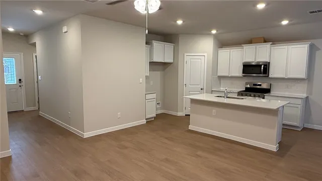 a kitchen with stainless steel appliances a refrigerator sink and microwave