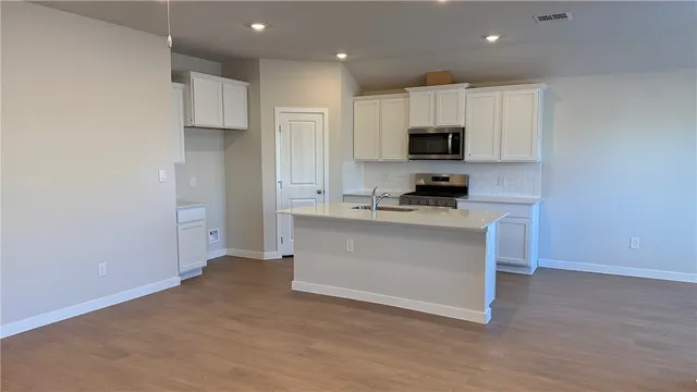 a kitchen with a refrigerator and a stove top oven