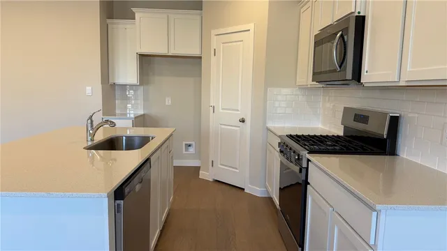 a kitchen with a sink stove and cabinets