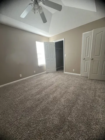 en empty room with windows and fan