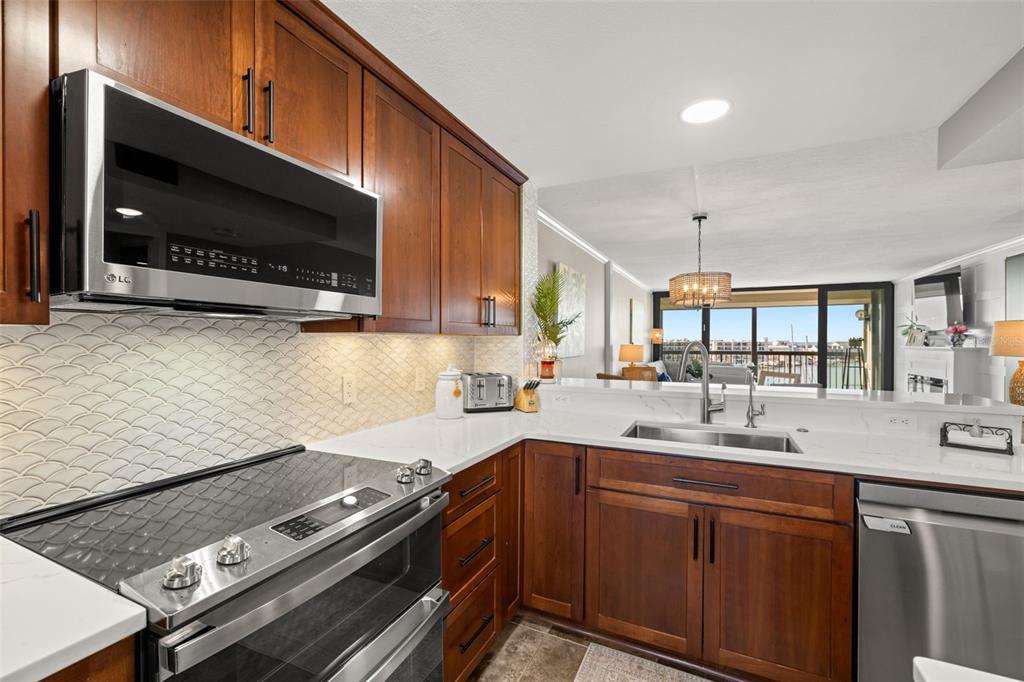 9525 Blind Pass Road, Unit 507 St. Pete Beach, FL 33706 - Photo 9 of 53 a kitchen with a stove and a microwave