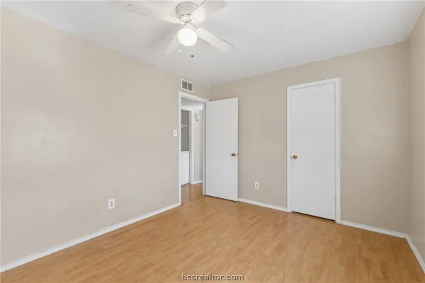 an empty room with a ceiling fan and a window