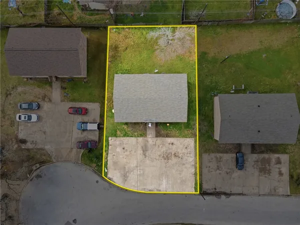 an aerial view of a house with a yard and pool